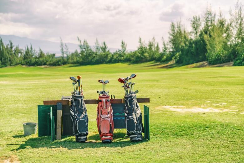 Golf bags are pictured on a course.