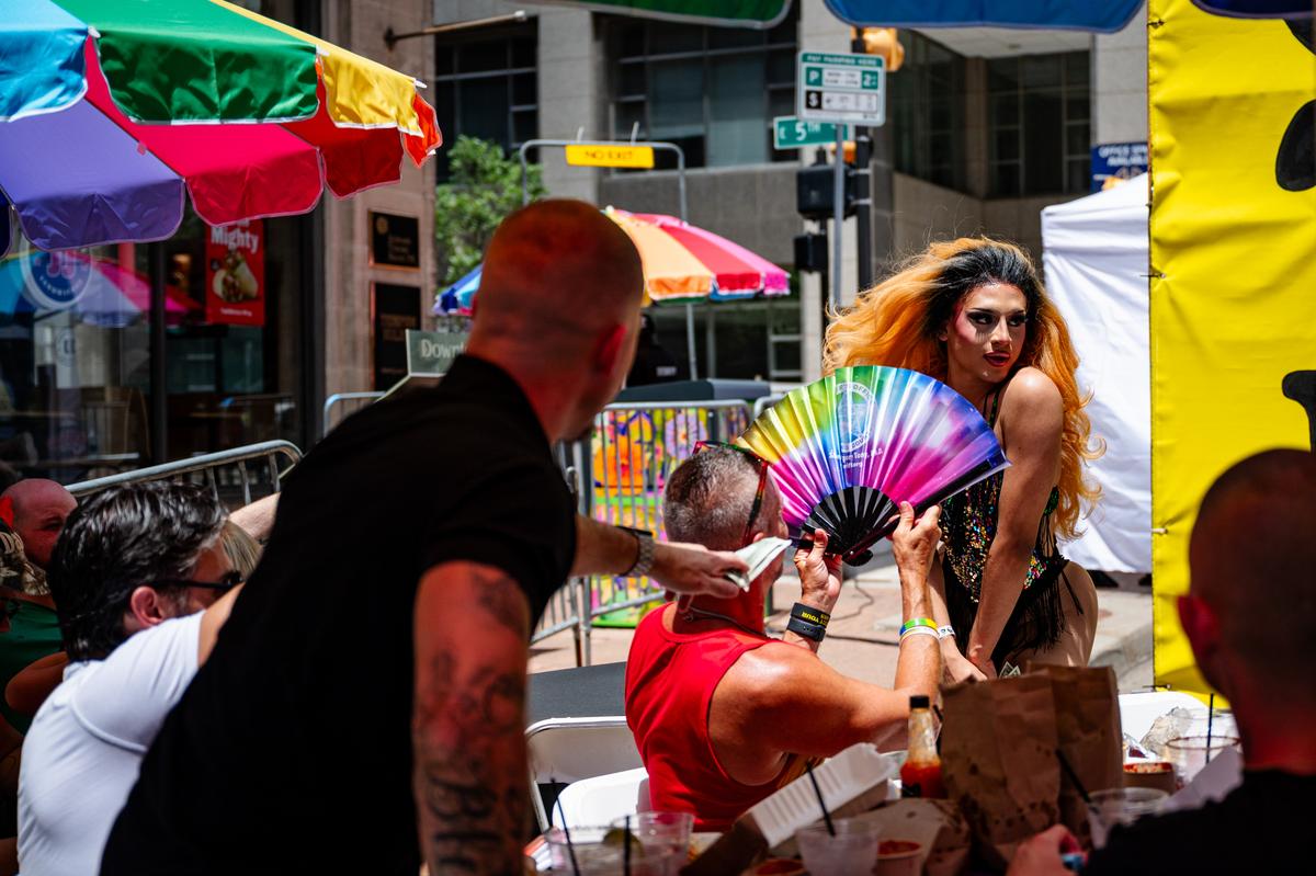 A drag queen cools off with an attendee's fan during the drag brunch at Elote on Saturday, June 27, 2026.