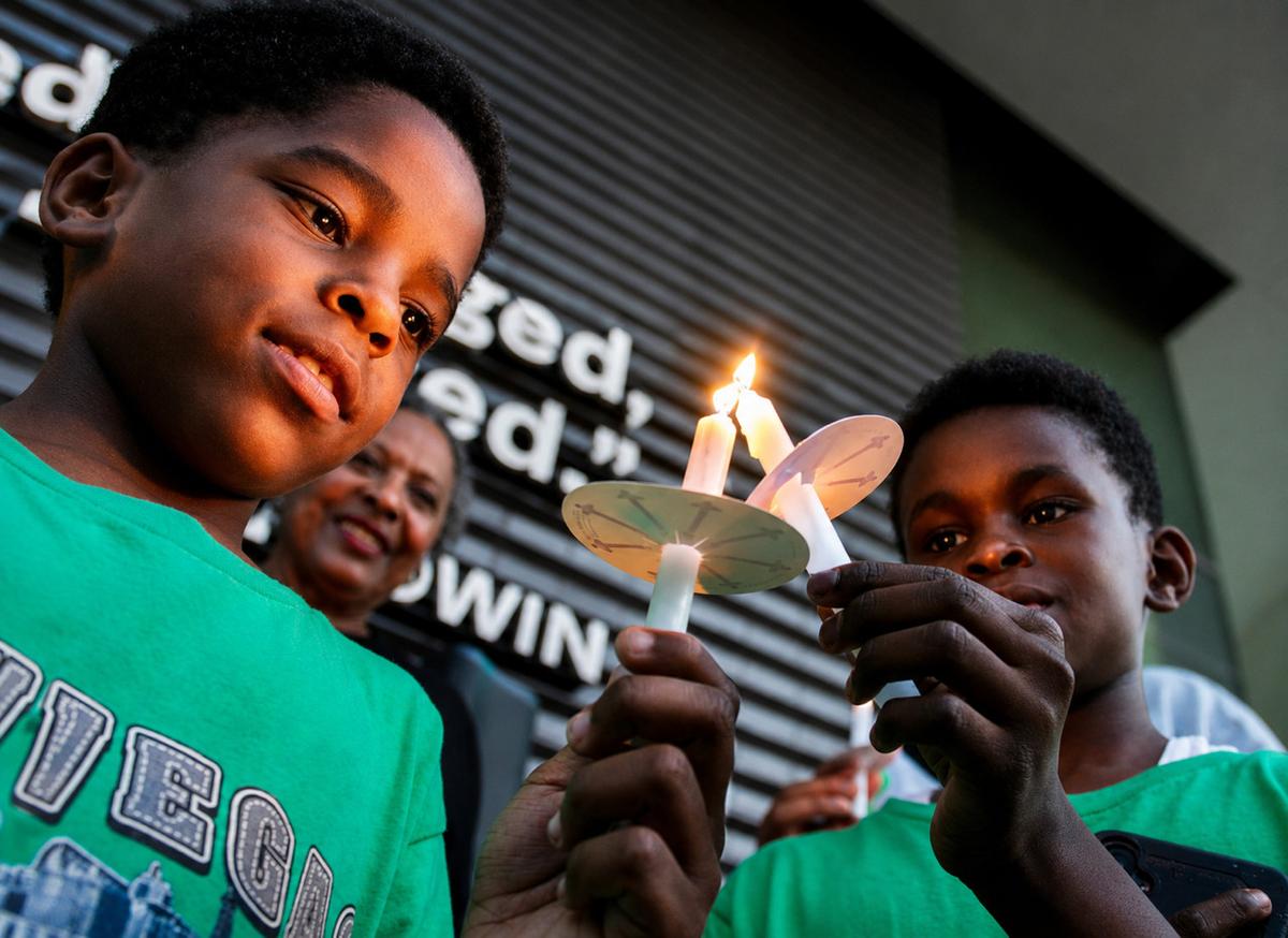 People gather during the Black Wall Street candlelight vigil at Greenwood Rising May 31, 2026.