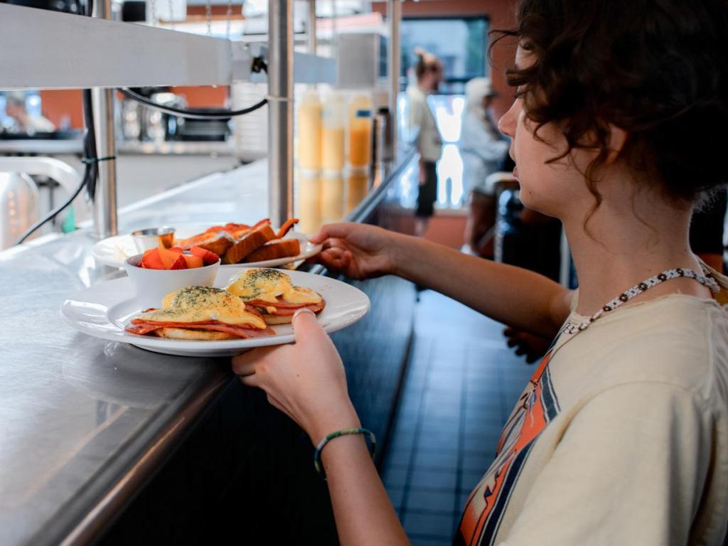 A server prepares to deliver eggs benedict and more at Bramble Breakfast & Bar, 1529 E. 15th St., on June 25, 2026. 