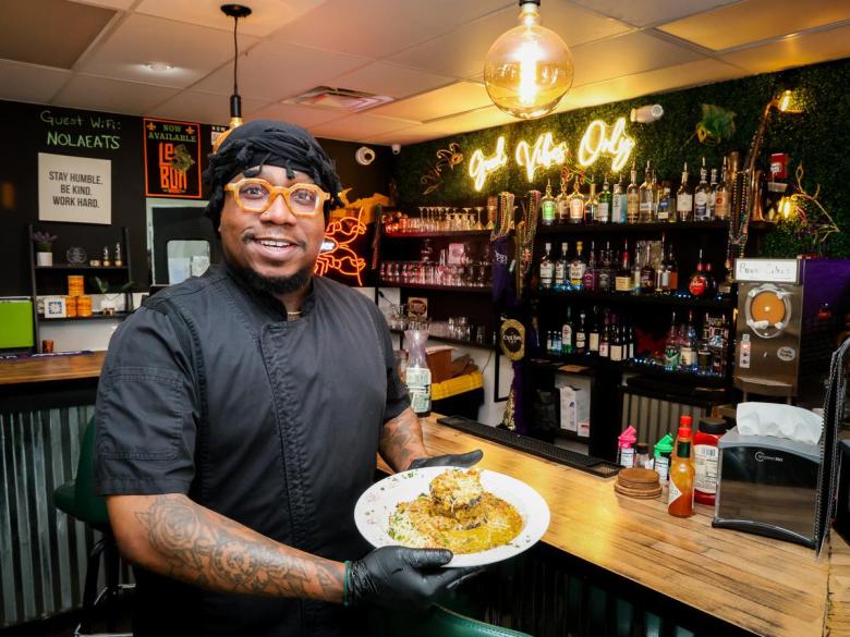 C’est Bon Kitchen &c Libations owner David Franklin holds a dish June 3, 2026. The restaurant opened inside Shoppes at Peoria at 1717 N. Peoria Ave. Suite 7 in July 2025.