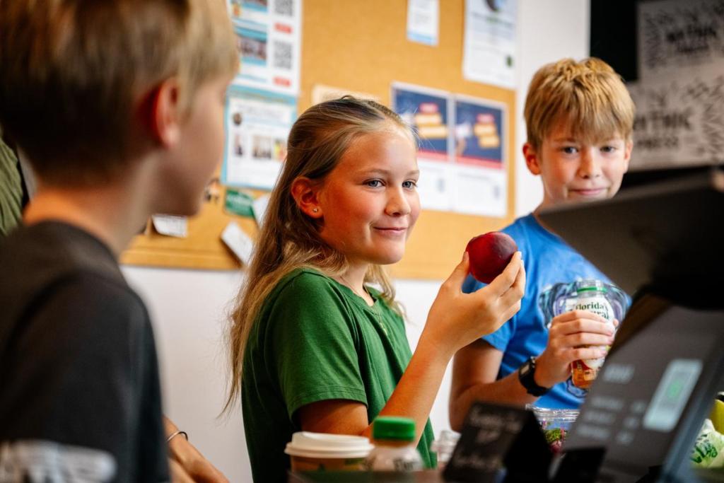 Florence Wheeler smiles as she is about to bite into a peach at CHOP Grocer on Thursday, June 25, 2026. 