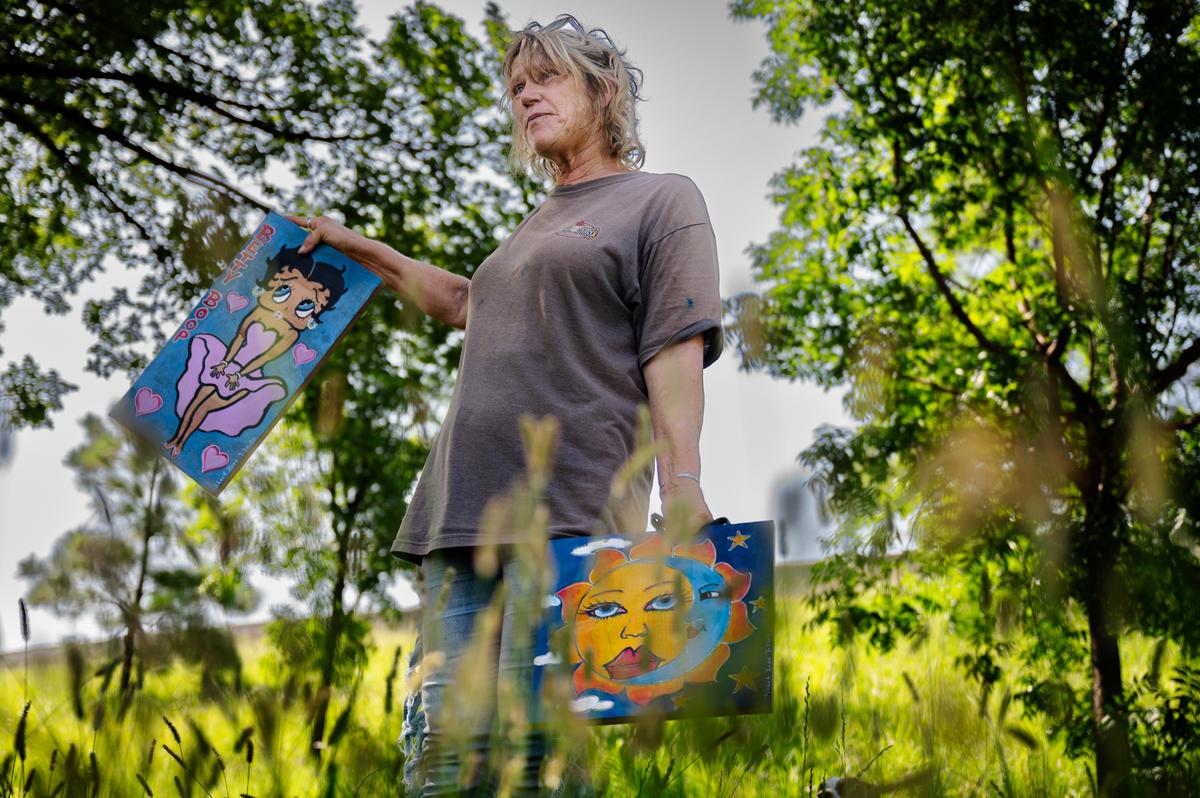 Charlotte Young shows off her artwork at her encampment on Tuesday, July 21, 2026.