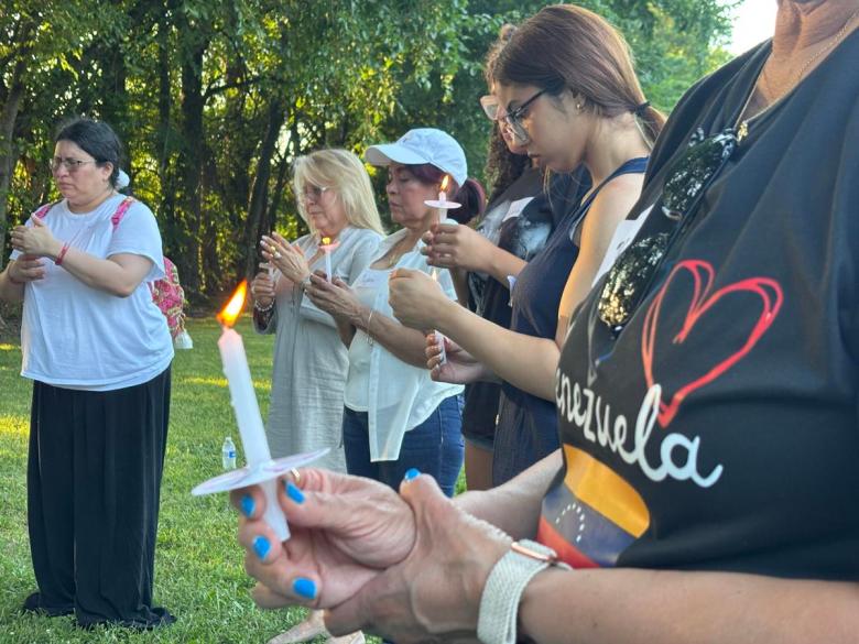 Members of Angeles en Tulsa hold candles and say a prayer on July 2, 2026, for Venezuela. The group spent the evening to honor the lives lost and unite as a community.
