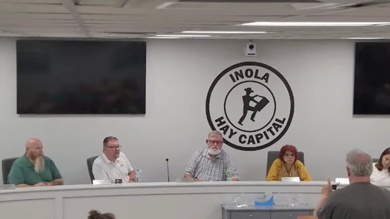 James Shaffer, bottom right, in gray shirt, submits his resignation to the Inola Board of Trustees on July 13, 2026.