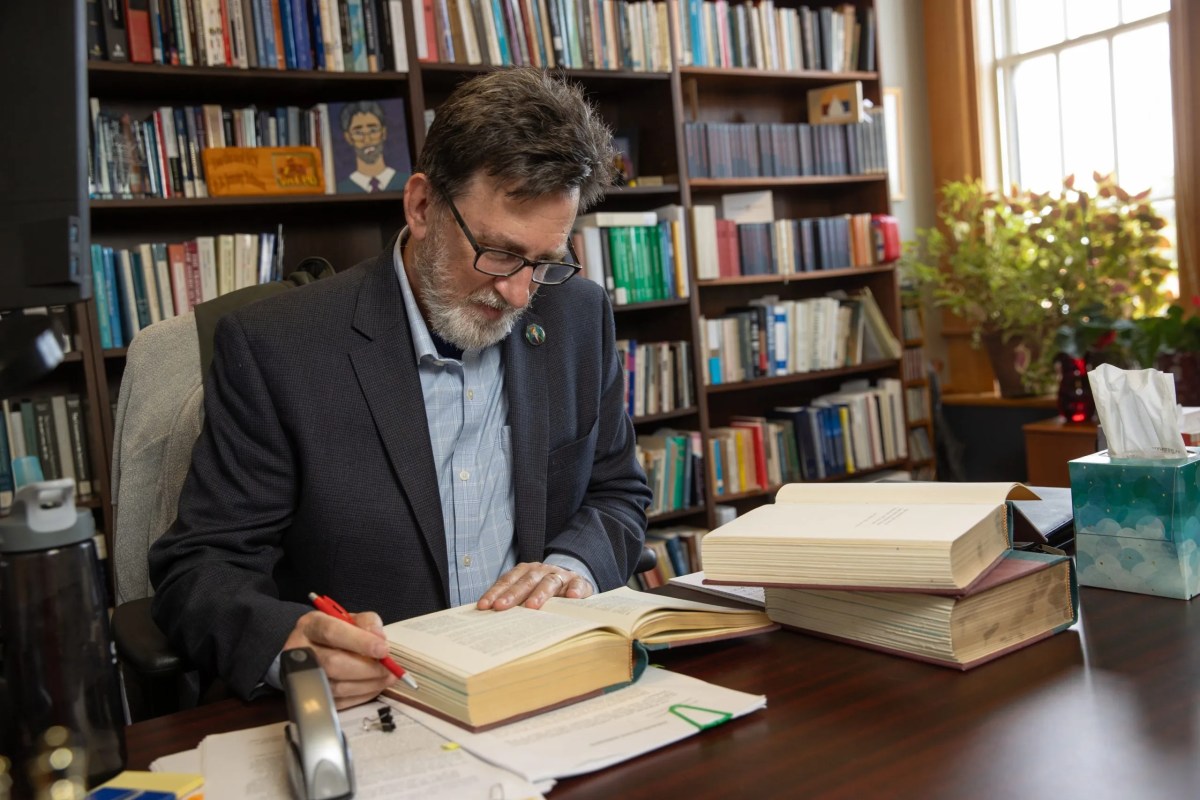 Jerry Telmen, a contracts professor at Oklahoma City University School of Law, browses a text in his office on July 7, 2026.