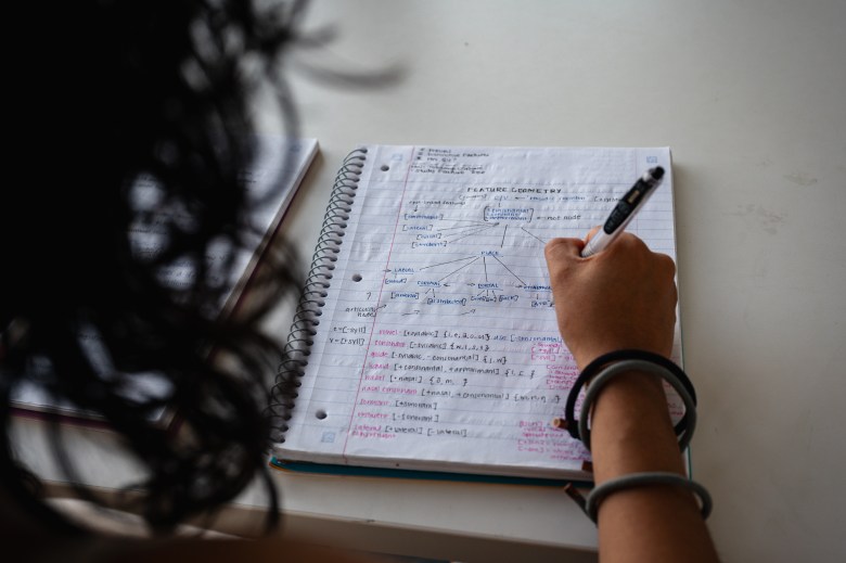 Maria Reynolds, a former University of Oklahoma student who dropped out following the end of in-state tuition for students without legal status in the U.S., writes in her notebook Aug. 19, 2026. She is using a pseudonym for fear of deportation.