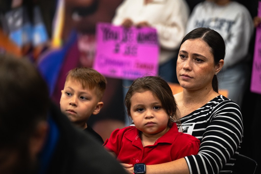 Ana Jimenez Montez sits with her children Benjamin and Claudia during the Tulsa Public Schools board meeting Monday, Oct. 19, 2026. Both children attend Mitchell Elementary School, one of the 17 campuses slated for closure.