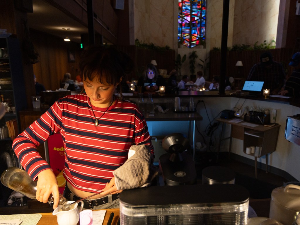 Wildflower Cafe barista Whitney Santana makes a drink during service inside the restaurant's Chapel Coffee Oct. 16, 2026.